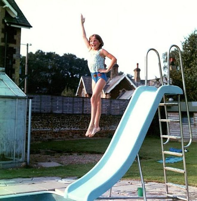 Always poised, even when jumping off a slide into the family’s pool at Park House, a youthful Diana shows off her fun side. Her red swimming badges can be seen at the bottom of her bathing suit.


