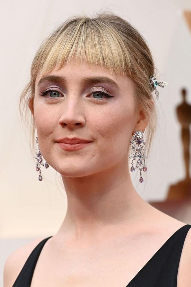 From her fresh new bangs to the butterfly clip and violet eyeshadow, Ronan's beauty look is a winner from all angles.

Photo: Robyn Beck / Getty