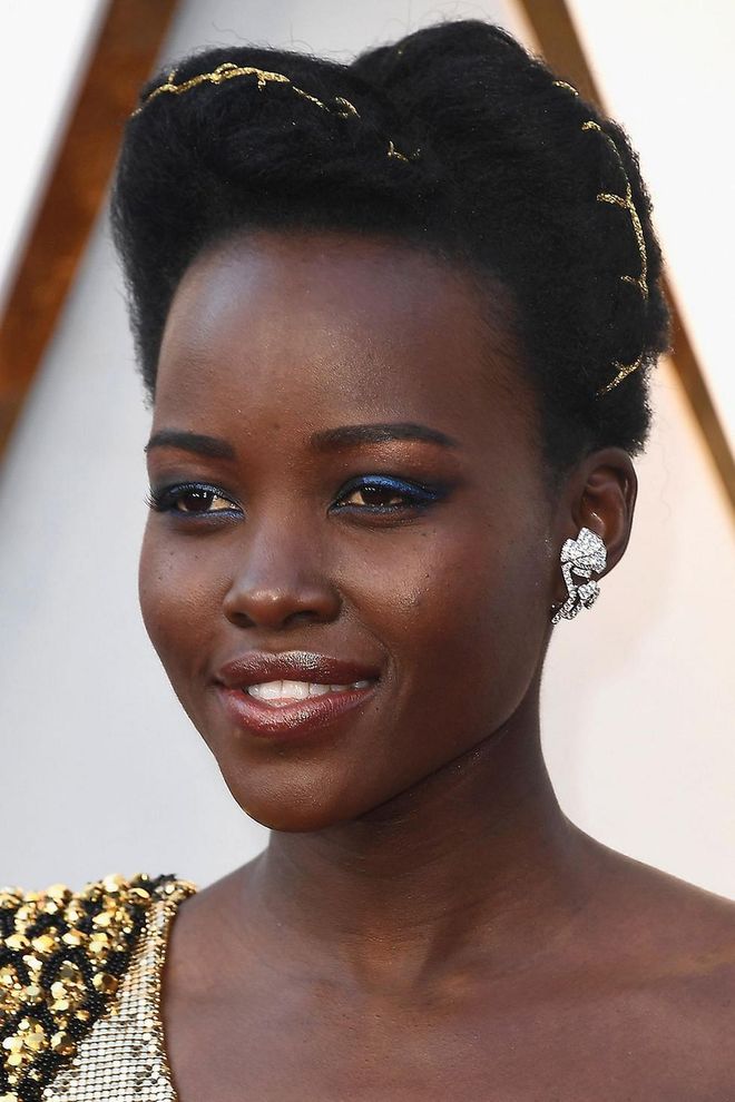 Navy blue offsets festive gold - and silver - a treat. Channel Lupita Nyong'o with smoky blue eye shadow. Try Stila's Vivid & Vibrant Eye Shadow Duo in Sapphire. Photo: Getty