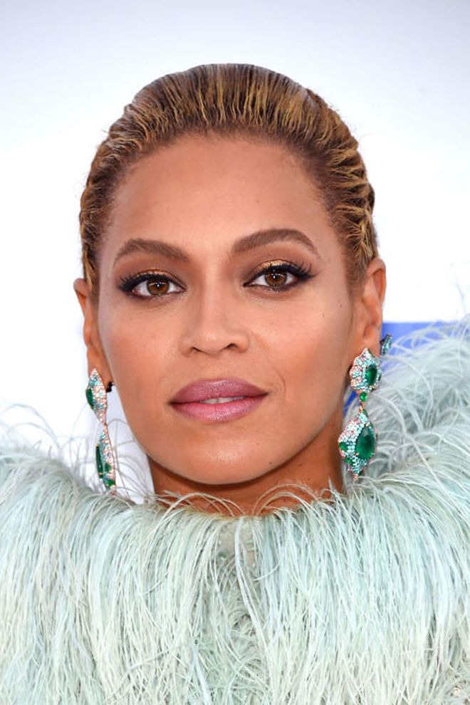 Queen Bey slicks back her caramel-blonde highlights to point all the attention to her bronzed smokey eyes and shimmery pink lips. 