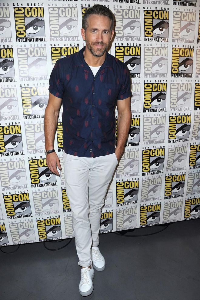 Ryan Reynolds in a smart navy short-sleeved shirt and white chinos.
Photo: Getty