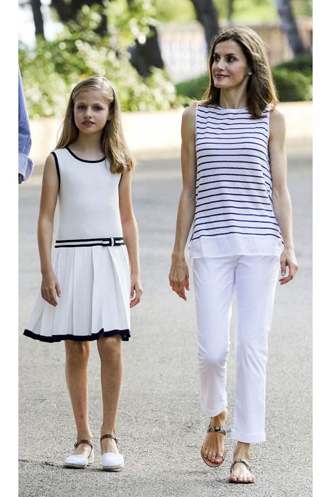 Queen Letizia does European casual well, too–here she is in summery white pants and a striped white and navy top with her daughter, Princess Leonor.
