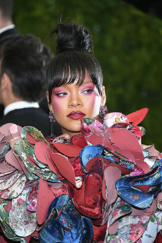 Side swept bangs and a high top bun gave the ever so fashion forward Rihanna a feminine sensibility with an edgy touch. (Photo: Getty)