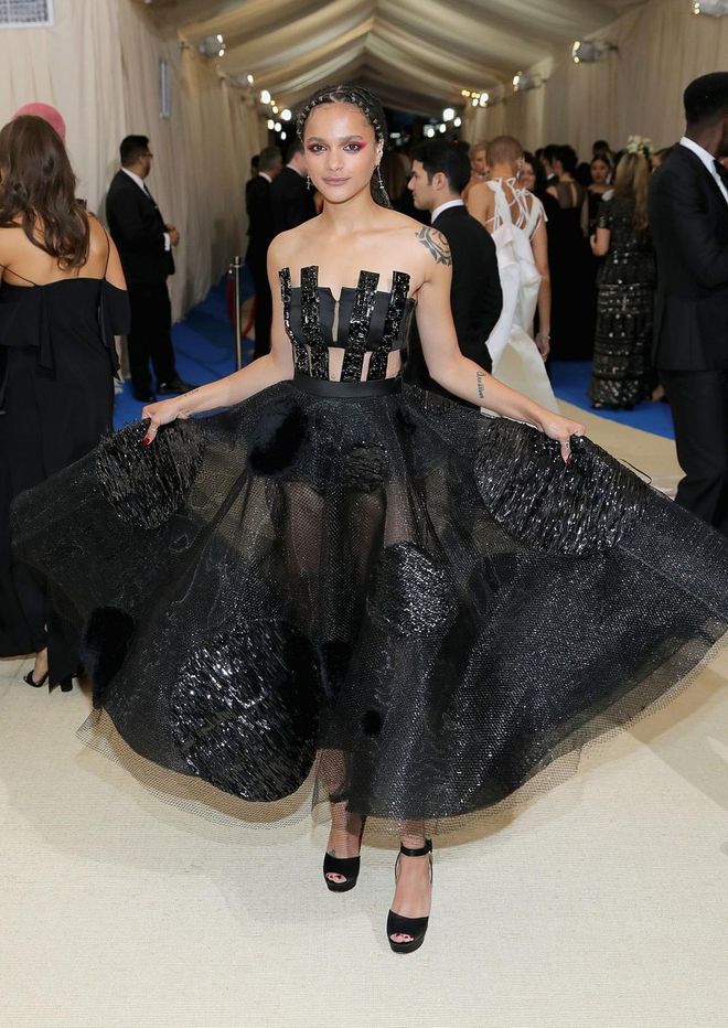 Sasha Lane goes dramatic with a sheer tulle black dress that features a cut-out corseted top. The froufrou skirt flashes bits of her legs and the top truly makes a statement. Photo: Getty 