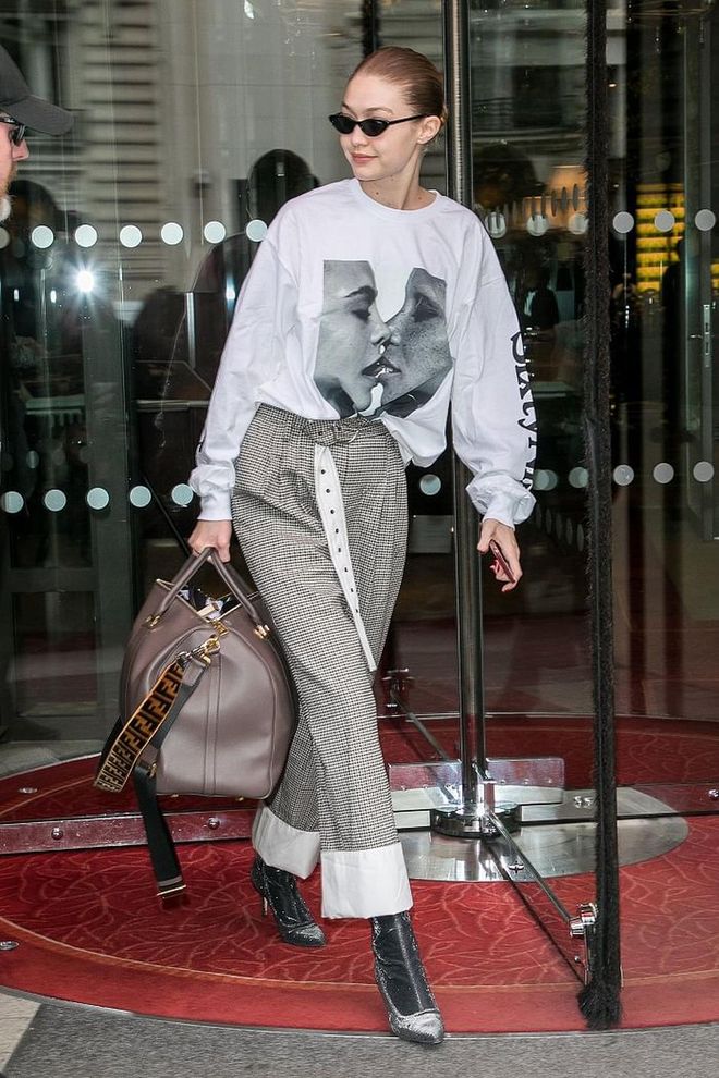 Gigi wore an image of Cara Delevingne and Adwoa Aboah  on her sweater, matched with high-waisted checked trousers. Booties and a massive Fendi bag finished off the look. 