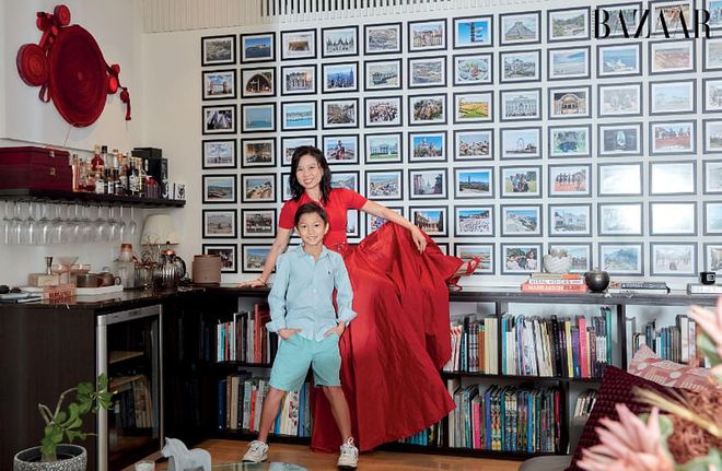 Dr Toh, in a Ralph Lauren top and skirt, sandals from Emblem, and her own Hermès bracelet, Cartier necklace and Tiffany & Co. ring, poses with her son in front of the family photo wall. Photo: Gan