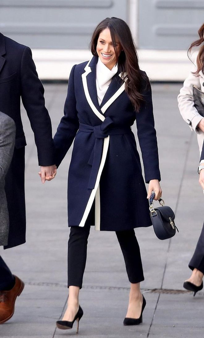 On International Women's Day, Meghan chose to wear navy again. This time, in the form of a wrap coat by J.Crew with a cream lined lapel. Meghan matched it with darker navy Alexander Wang trousers and a navy ALTUZARRA 'Ghianda' Saddle bag. She seems to be a huge fan of monotone dressing!