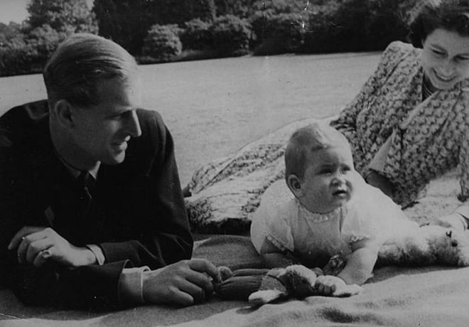 Philip and the Queen with their one-year-old son Prince Charles in the gardens of Windlesham Moor in Surrey, England.