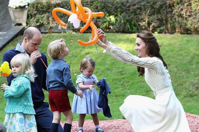 The Duchess plays with balloon animals on the grass with Prince William, Prince George, and Princess Charlotte while at a party for military families during a royal tour of Canada.
Photo: Getty