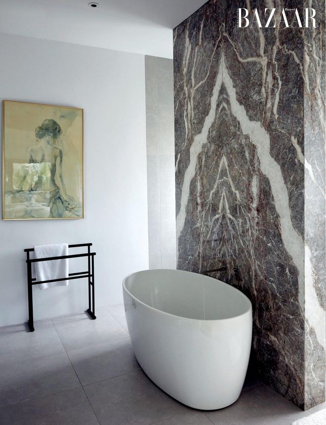 The master bathroom has a stunning book matched marble feature wall.