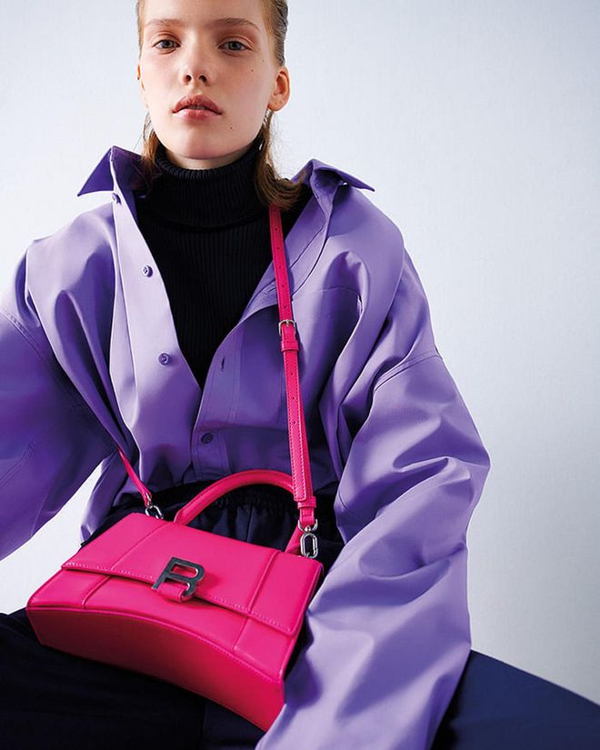Hourglass top handle S bag in acid fuchsia. Poplin shirt; cotton and cashmere ribbed knit turtleneck; terry cotton jersey tracksuit pants. 
