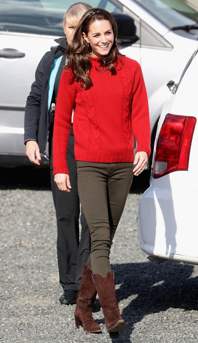 The Duchess of Cambridge paired a red knit sweater with olive green skinny jeans and a pair of suede boots for a day out fishing. Photo: Getty