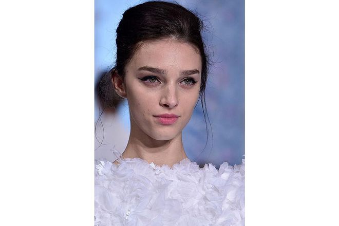 Elegant is the word that perfectly sums up the hair and make-up at Ralph & Russo for Spring 2016. Each model was given a feminine flick of liner and a delicate pink lip, while hair was fastened into a chignon ; Photo: Getty