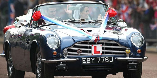 William at the wheel of a vintage Aston Martin sports car decorated with wedding regalia.
Photo: Getty
