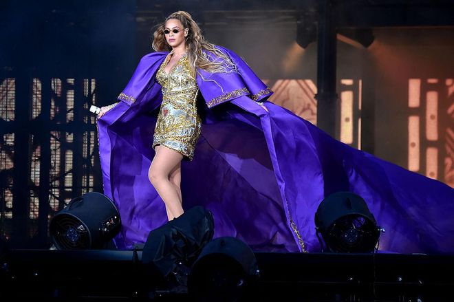 In a Dundas purple silk cape and gold embroidered mini dress. Photo: Getty