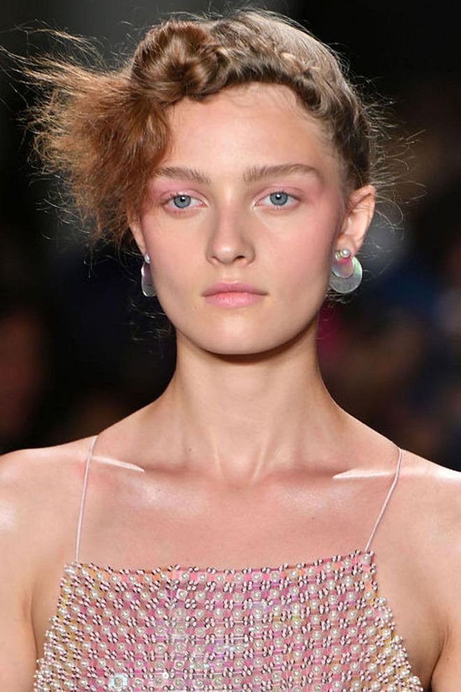 The Look: That '80s Glow
How-To: You can blame it on Stranger Things. The '80s are back and they're fresher than ever; just look at the glowing pink makeup seen backstage at Adam Selman. After prepping and moisturizing the skin, makeup artist Emi Kaneko traced a rosy, multipurpose cream color (MAC Casual Color in For Your Amusement) across the cheekbones, up toward the eyes, and all over the eyelids, giving that distinct '80s draping effect. The color was also dabbed on the lips. But it's the way the skin looks shiny, raw, and unfiltered that makes this one of the coolest looks thus far. It might be the beauty nerd in us, but there's just something we love about classic application techniques twisted to appeal to a modern aesthetic. Photo: Getty
