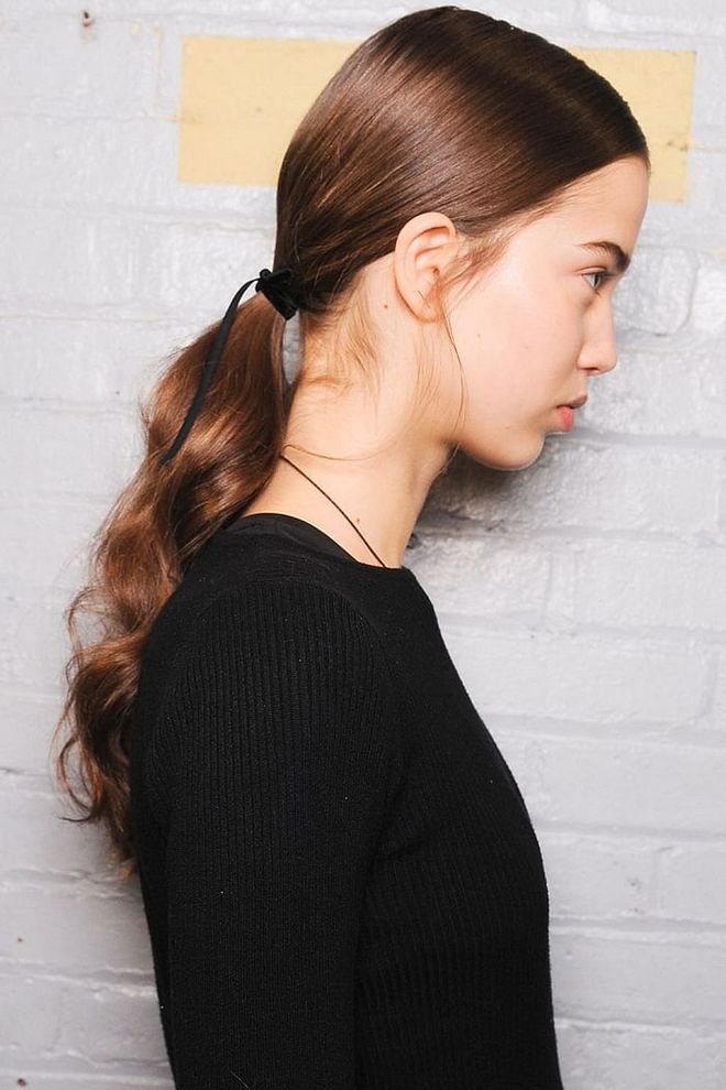Jonathan Simkhai's take on the ribbon ponytail: low and wavy, but with a skinny ribbon that's actually a string. The effect is more sleek than schoolgirl.