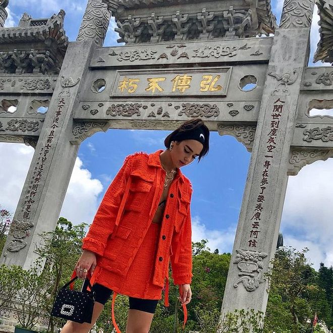 Dua has always had a thing for the whole classy and casual combo, and she has no doubt done it again; she wore this orange MSGM orange tweed jacket and skirt set, sporty Marine Serre half-moon headband, and dainty Roger Vivier purse to get on some tourist duties in Hong Kong. Jealous?
Photo: Instagram