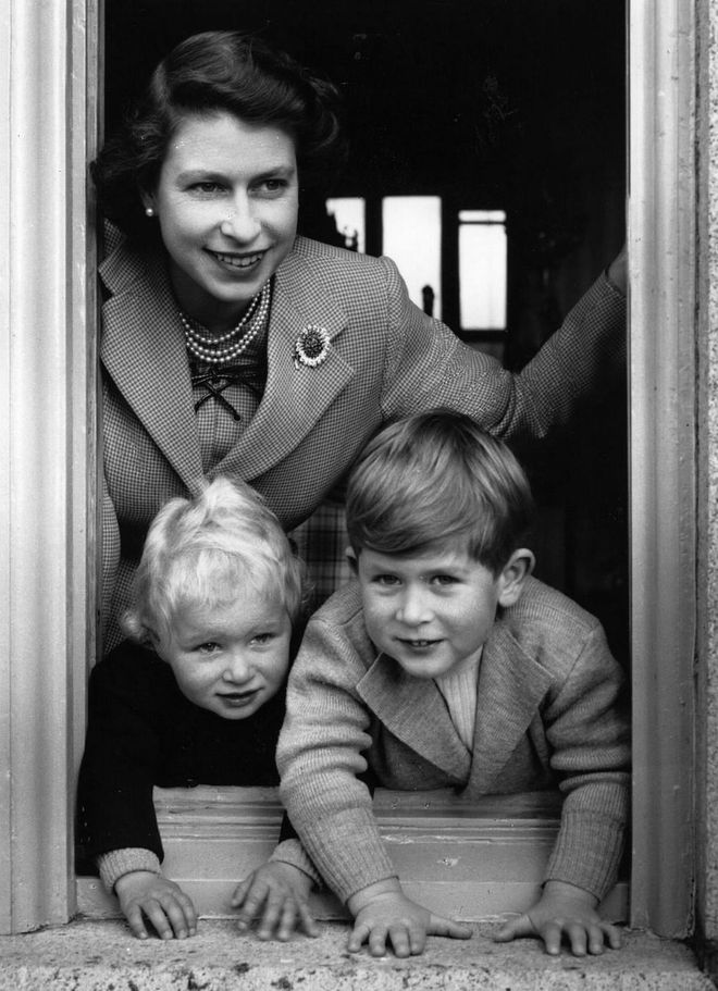 Prince Charles and Princess Anne peek out a window at Balmoral Castle in Scotland under mom's watchful eye. A year prior to Elizabeth's coronation, life was simple for the family of four.