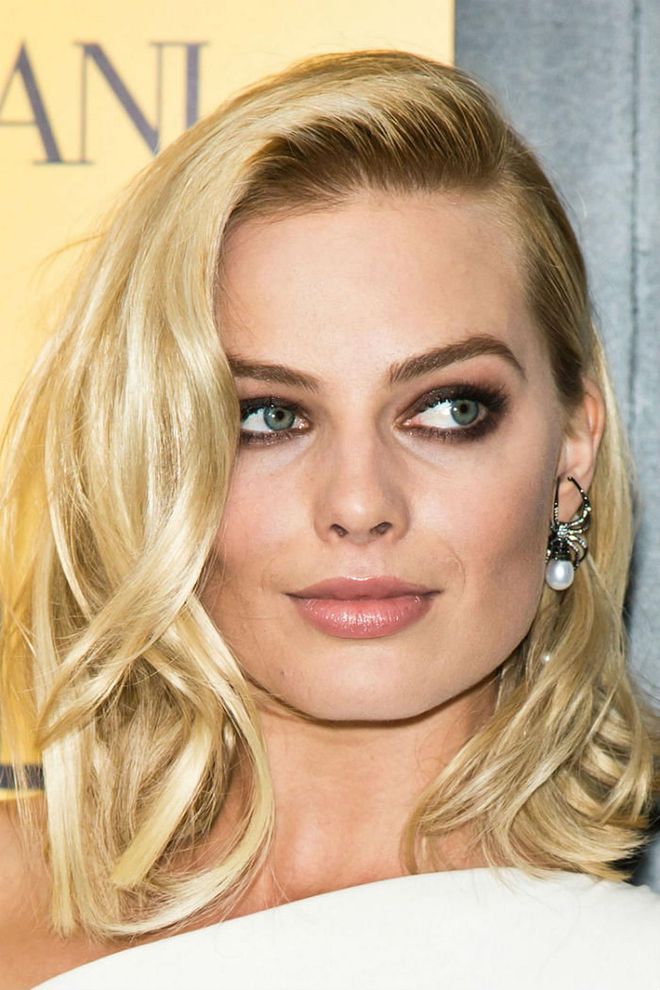 Dark roots and chocolate smoky eyes provide just the right amount of contrast against Margot Robbie's golden waves.