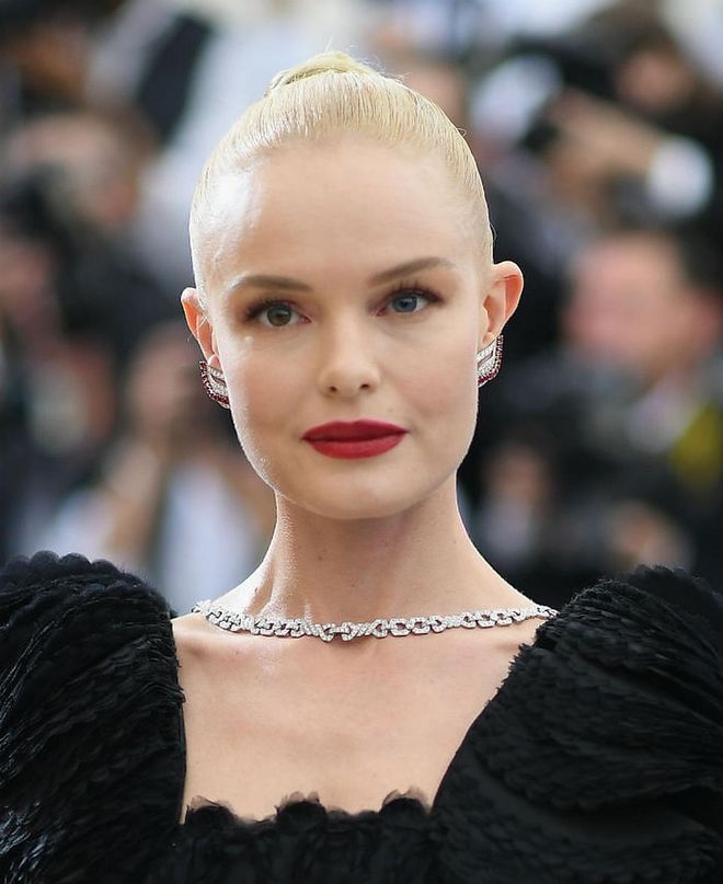 Showing off a classic makeup look of bold red lips, shadowed eye lids, and contoured cheekbones is Bosworth's sleek bun tied high on her head (Photo: Getty)