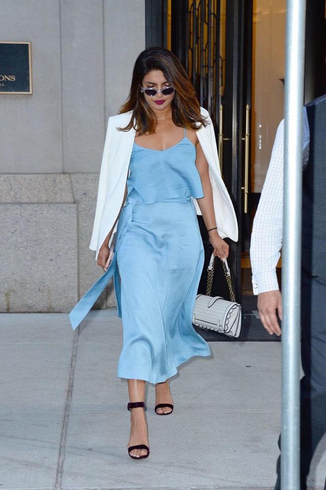 Priyanka stuns in this pale blue two-piece! She casually drapes a white jacket over her shoulder that matches her Bottega handbag. Photo: Getty