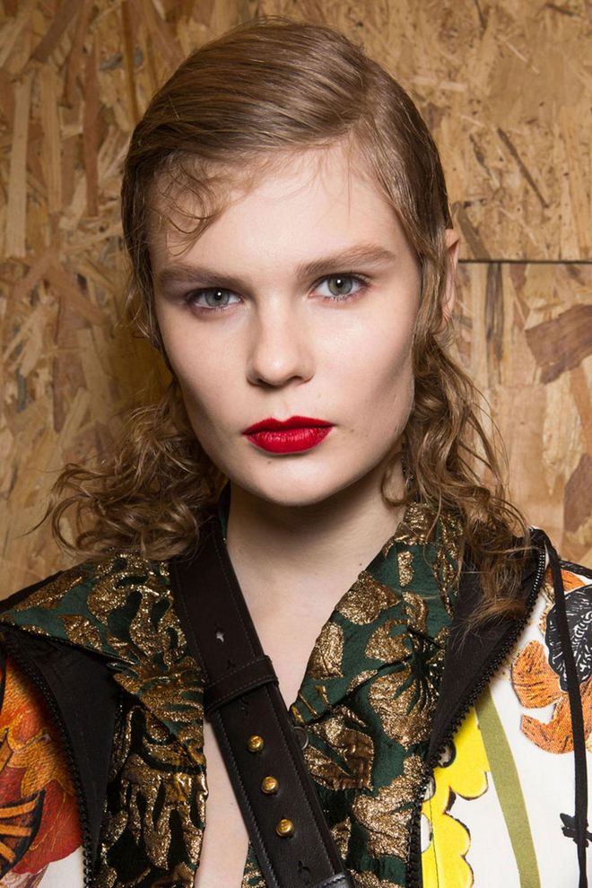 The Prada woman for autumn/winter 2016 is strong and independent. To portray this, the make-up artist Pat McGrath blended her own bold, matte red lip colour, while the hair stylist Guido Palau created a textured look with curls from the mid-length down.