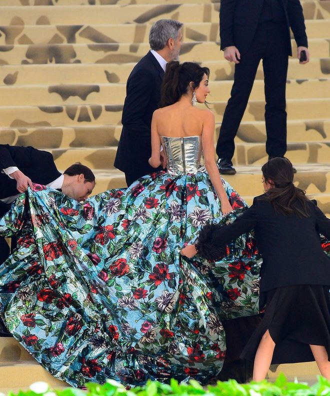 Despite being in pants, the floral parachute behind Amal made it a hassle to get up the steps. Photo: Getty 