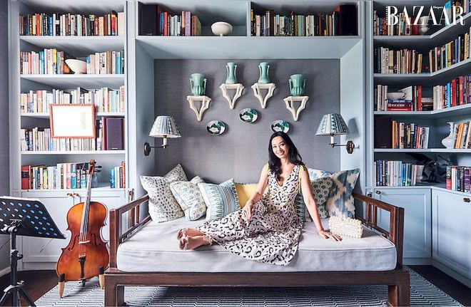 Long, in a Self‐Portrait dress, Alexandre Birman sandals, wedding ring (worn throughout) and rings from Simone Jewels and Madly Gems, on the daybed in the study room.