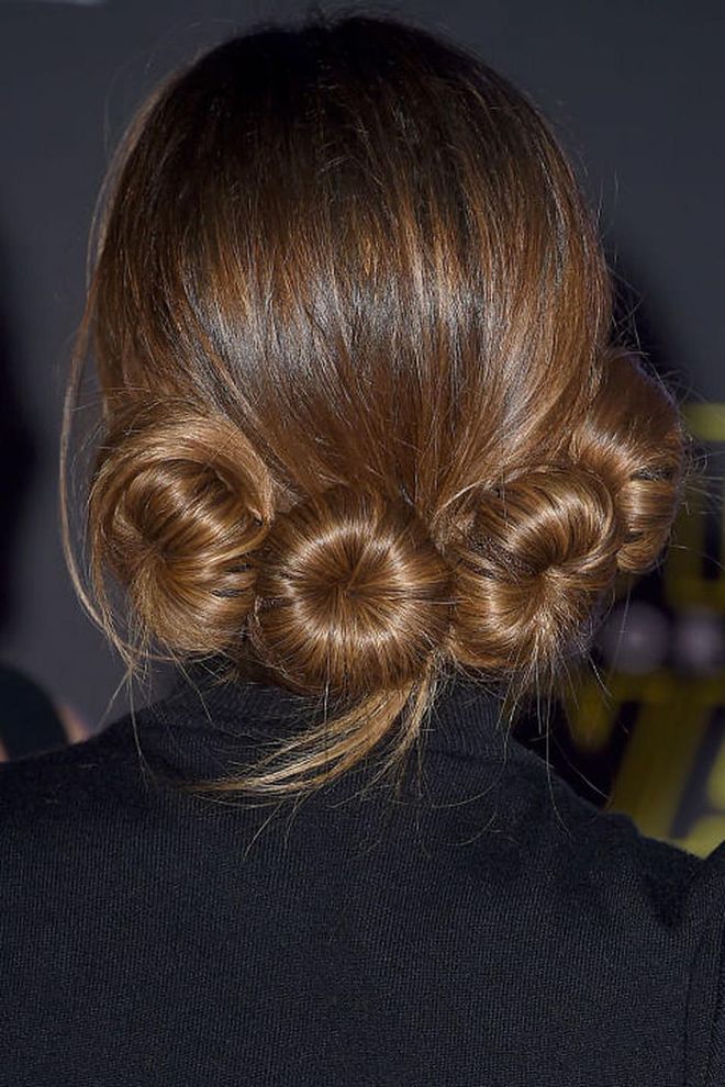 The only thing cuter than one miniature chignon is a set of four. Begin with a sleek blowout to boost shine and keep those ends straight so they escape, like so. Photo: Getty