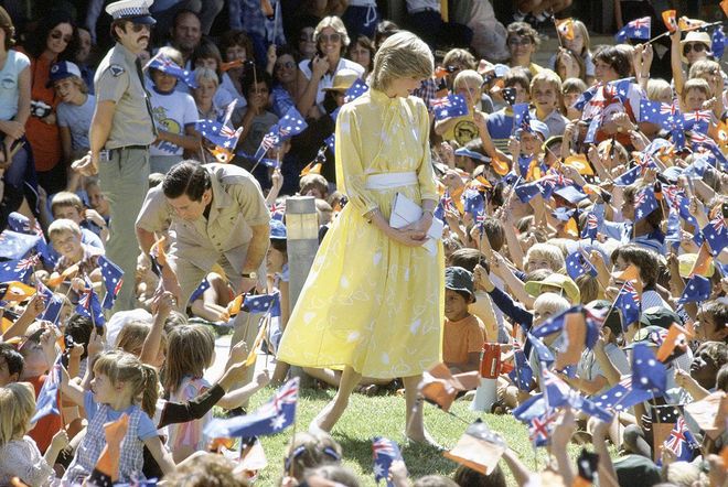 In a belted yellow dress while visiting schoolchildren in Alice Springs with Prince Charles. Photo: Getty