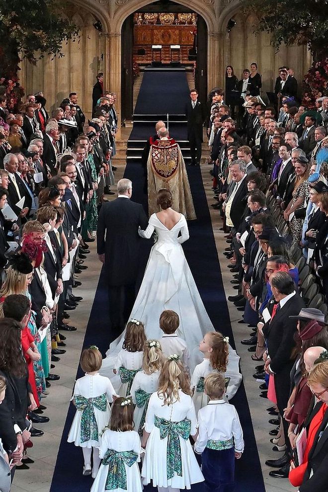 Princess Eugenie and Prince Andrew walk down the aisle, followed by her bridal party.