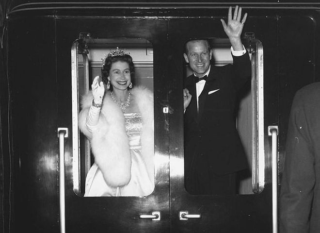 Queen Elizabeth II and Prince Philip wave as they leave Liverpool after attending a "Snow White and the Seven Dwarfs" ice show.