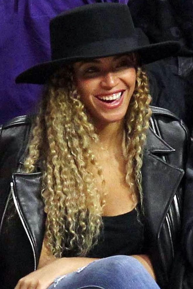 Bey makes curls look edgy with an all-black courtside ensemble. Photo: Getty