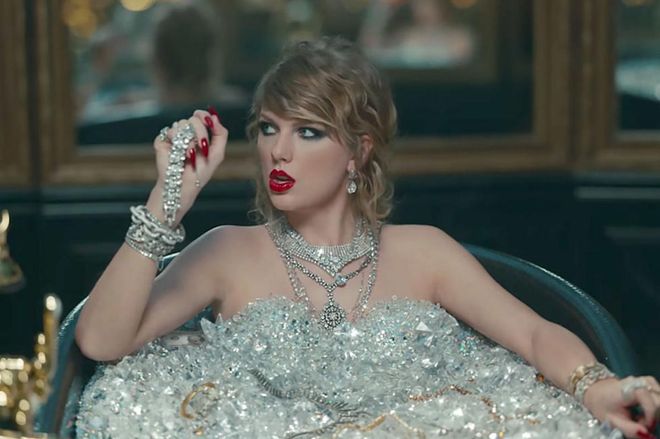 While taking the world's most-painful bath to wash the dead off of her, Taylor rocks a super-smudgy cat eye, a loosely curled chignon, and some vinyl red lips to match her dangerously sharp nails. 