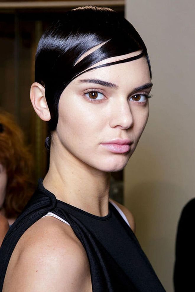 The Look: Boyish Charm
How-To: It's best to expect the unexpected from the beauty look at Givenchy. At any given show, a model could walk the runway with their face bedazzled or taped back. But this season's take on beauty took a decidedly fresher approach. Makeup artist Pat McGrath said the look had a "boyish" feel. In makeup, that translated to just grooming: touch-ups with concealer where needed and brows filled-in or fluffed. And that's it. It was the hair that really brought that message of boyish charm home. Combed forward and slicked across the face, hairstylists utilized a ton of gel to create the almost helmet-like shine seen from the runway. Even more shine was added by way of Redken Diamond Oil mist when the hair was twisted and pinned in the back into a low chignon.
