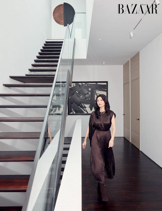 Claire Wu in the hallway of her home wearing a dress and boots by Hermès, and her own Van Cleef & Arpels necklace, Cartier bangle and Monica Vinader rings (worn throughout)