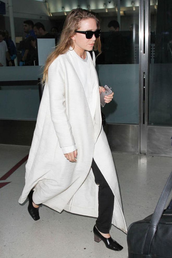 Mary-Kate Olsen paired her signature sunglasses with a long white coat. Photo: Getty