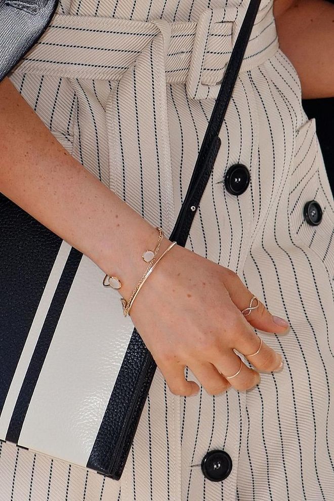 Meghan Markle shook hands with people at the Commonwealth Heads of Government Meeting in April wearing thin bands on nearly every finger, including her thumb. The move was "unusual for a British royal to do," Kay says, but she'd done it before on a trip to Scotland. (Pssst: That gorgeous open bracelet from Tai is only $65.) Photo: Getty