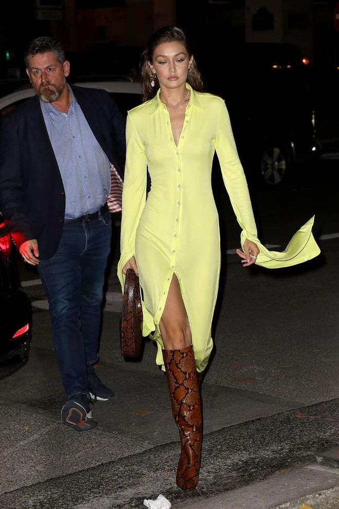 Gigi Hadid arrives at a party in snakeskin boots and a yellow shirt dress with exaggerated sleeves.

Photo: Getty