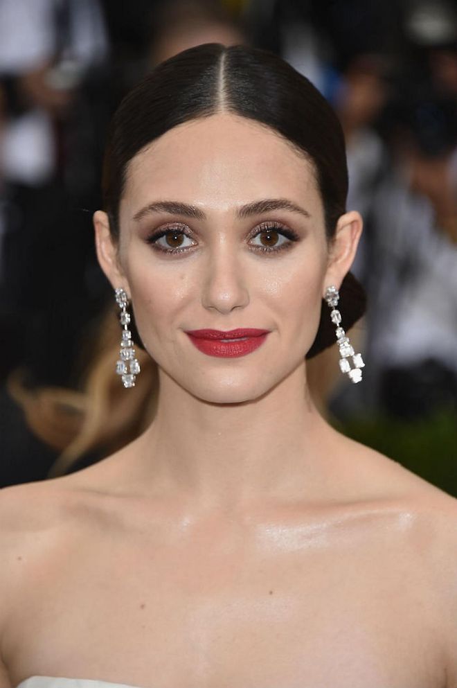 Rossum's metallic chocolate eye shadow, fair skin, and deep scarlet lips is the look to go for if you're going for a classically glamorous beauty look (Photo: Getty)
