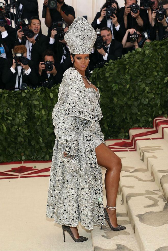 Delivering another jaw-dropping Met Gala look, Rihanna showed up to this year's Heavenly Bodies: Fashion and the Catholic Imagination theme looking like a high fashion pope. The singer stunned in a pearl and jewel-encrusted robe, matching papal mitre, and necklace designed by Margiela—which easily became the most memorable look from this year's fashion event.