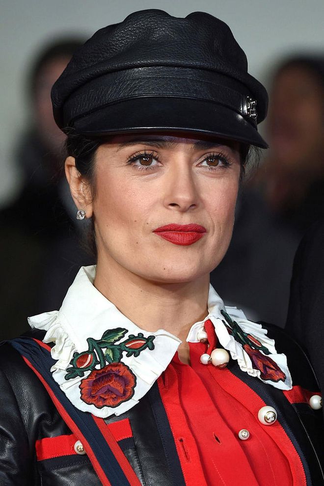 The actress accessorized her rose-embroidered shirt with a leather cap and matte red lips.
