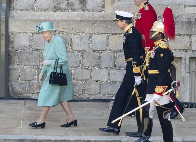 Per Hello!, Queen Elizabeth wore "a muted jade outfit by Stewart Parvin" for the occasion. The publication also noted that Her Majesty wore her Welsh Guards brooch for the ceremony, and a floral dress.