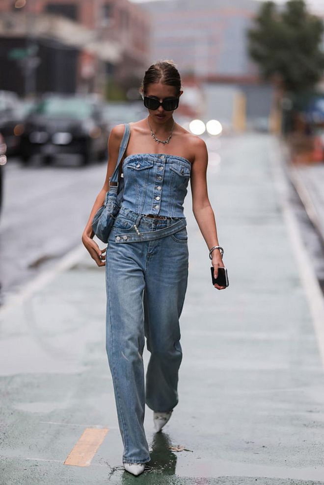 NEW YORK, NEW YORK - SEPTEMBER 11: Sophie Janovich is seen wearing black shades, silver necklace, light blue denim ZARA tube top, light blue denim jeans, white leather Balenciaga Cagole boots and light blue denim shoulder bag, before Tommy Hilfiger, during New Yorker Fashion Week on September 11, 2022 in New York City. (Photo by Jeremy Moeller/Getty Images)
