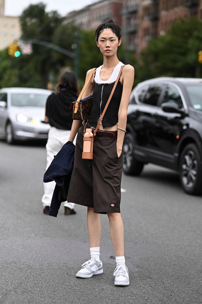 NEW YORK, NEW YORK - SEPTEMBER 11: Model Sijia Kang is seen wearing a black shirt, brown shorts and white Nike sneakers outside the Ulla Johnson show during New York Fashion Week S/S 2023 on September 11, 2022 in the borough of Brooklyn, New York. (Photo by Daniel Zuchnik/Getty Images)