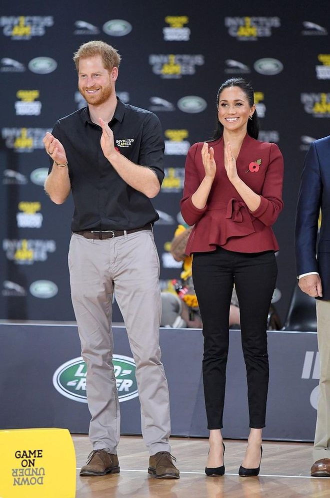 Meghan attended the Invictus Games wearing a maroon Scanlan Theodore top and black high-waisted denim with  Sarah Flint tortoise shell heels. 