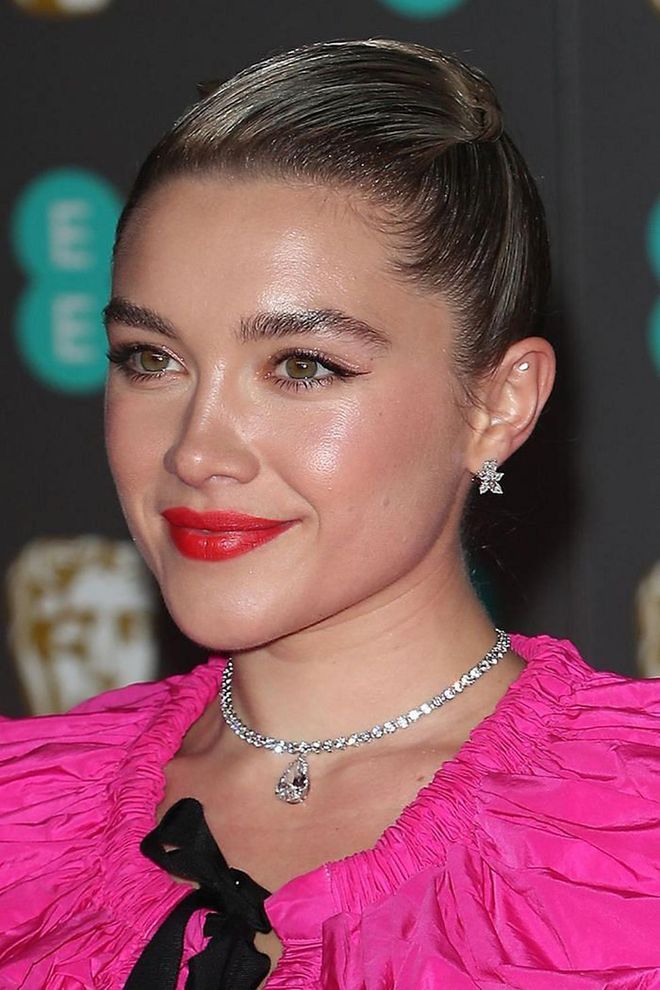 “I wanted to recreate the feeling of magic — fresh-faced and glowing," said the make-up artist Naoko Scintu about Florence Pugh's beauty look. It involved a bold red lipstick and delicate eyeliner flicks, which were balanced by her slicked-back hair.

Photo: Getty