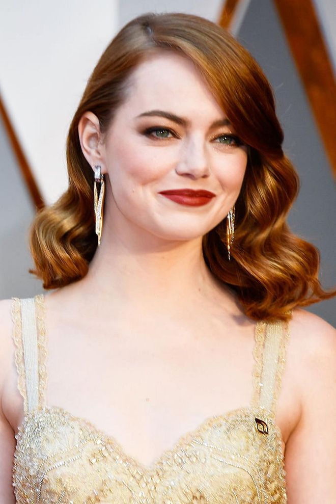 Channeling old Hollywood glamour, Emma Stone opts for perfect curls, a deep red lip and bronzed eyeshadow. 

Photo: Getty Images
