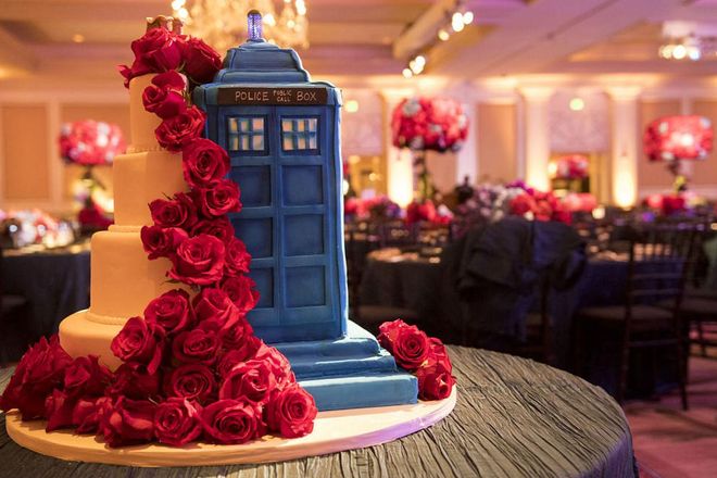 The wedding cake, designed by Joan and Leigh Cakes, was split in two; half traditional tiers adorned with red roses, half fondant replica the same ode to Dr. Who the wedding invitation took inspiration from. Photo: Lara Porzak